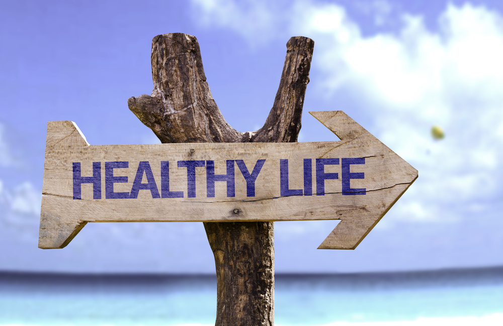 Healthy Life wooden sign with a beach on background