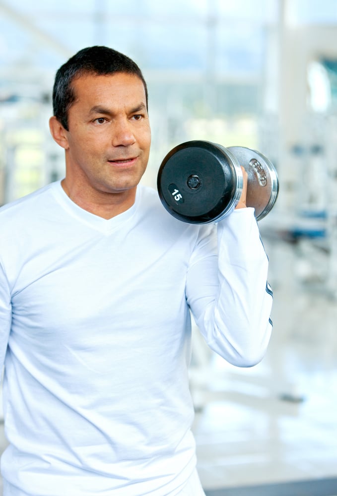 man at the gym doing free weights exercises